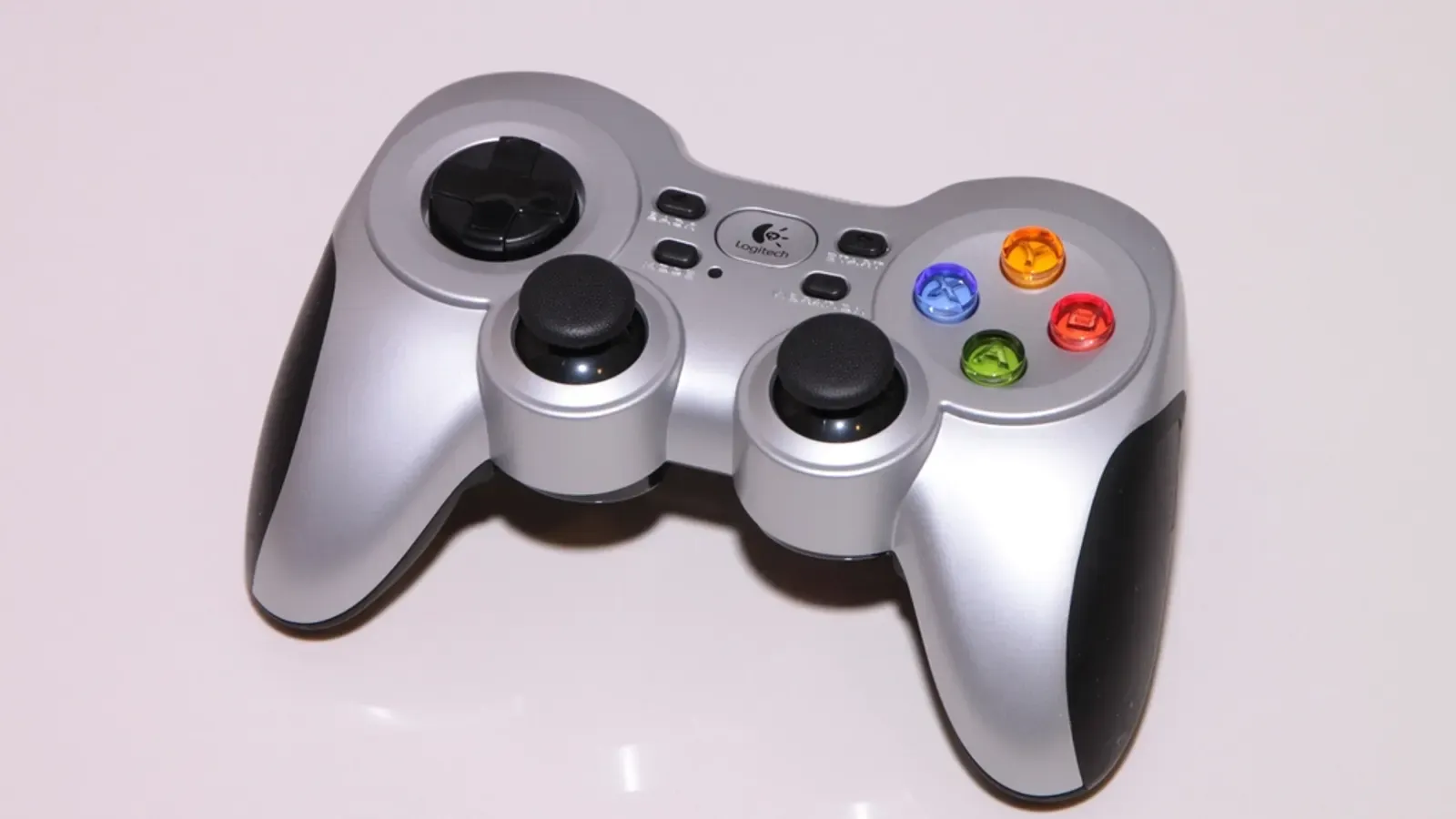 Controle de videogame prateado sobre fundo claro